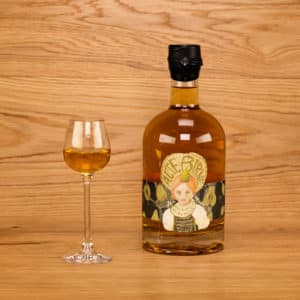 Alte Birne Holzfassbrand in dekorativer Flasche mit hübscher Etikette und Wachsverschluss mit eingeschenktem Schnapsglas