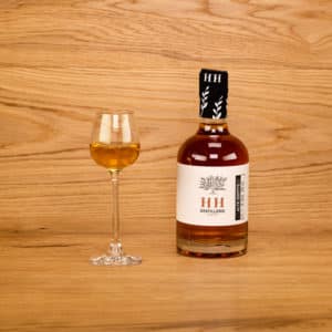 Alte Quitte in dekorativer Flasche mit eingeschenktem Schnapsglas