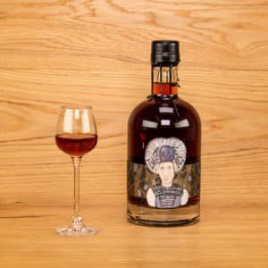 Alte Zwetschge mit dekorativer Etikette und Wachsverschluss mit eingeschenktem Glas