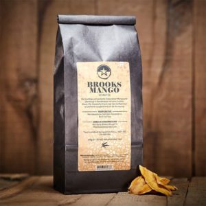 Brooks Mango Verpackung mit Früchten davor auf Holztisch