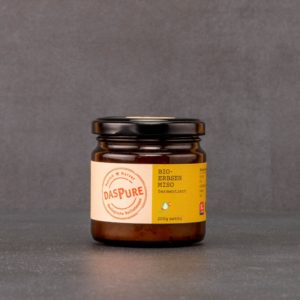 Miso 12 Monate fermentiert im Glas vor grauem Hintergrund