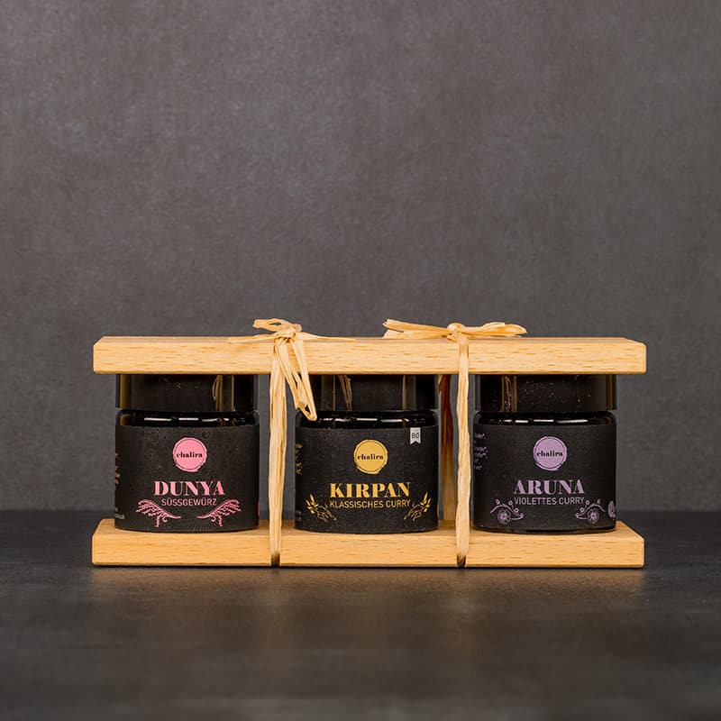 Geschenkset farbenfroh drei Gewürze zwischen zwei Holzbrettchen mit Bastbändern zugeschnuert