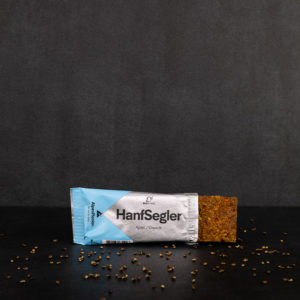 Bio Riegel Hanfsegler halb ausgepackt mit Hanfnüssen daneben