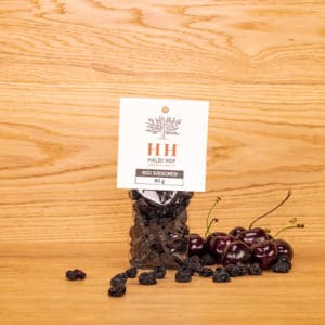 getrocknete Kirschen in durchsichtiger Verpackung mit Früchten im Hintergrund