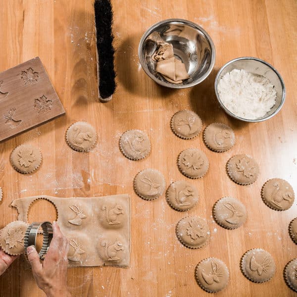 Ausgestochene Biberli mit Holzmodel, Mehlschüssel und einem Ausstechrad