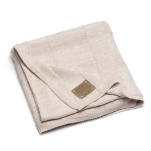 Gefaltete beige Babystrickdecke mit Lederetikett