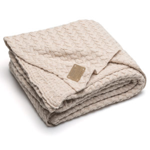 beige Strickdecke mit Zopfmuster gefaltet