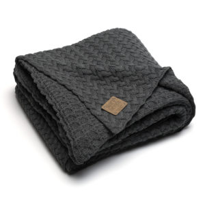 Graue Strickdecke mit Zopfmuster schön gefaltet