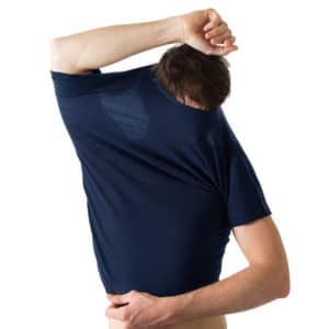 Mann zieht blaues Merino Shirt über den Kopf