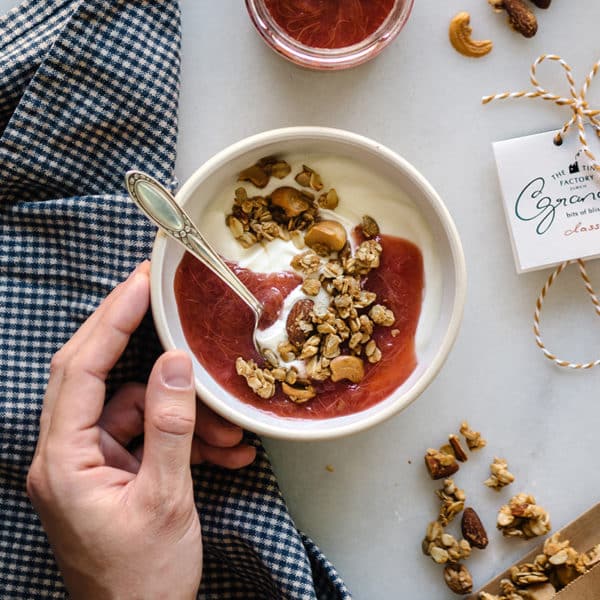 Granola in Schüssel mit Hand, welche die Schüssel hält