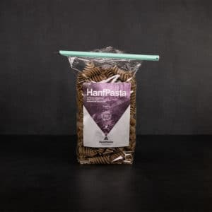 Mittelgrosser Tuetenhueter verschliesst eine offene Packung Hanfpasta