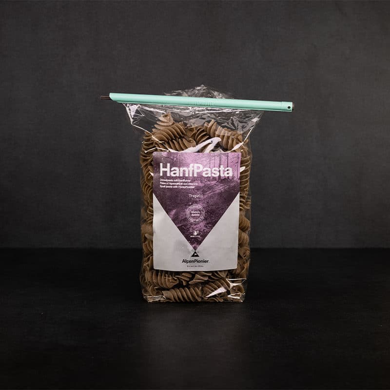 Mittelgrosser Tuetenhueter verschliesst eine offene Packung Hanfpasta