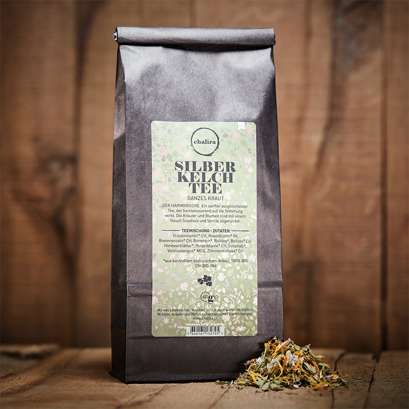 Silberkelchtee in Verpackung und offen davor auf Holztisch